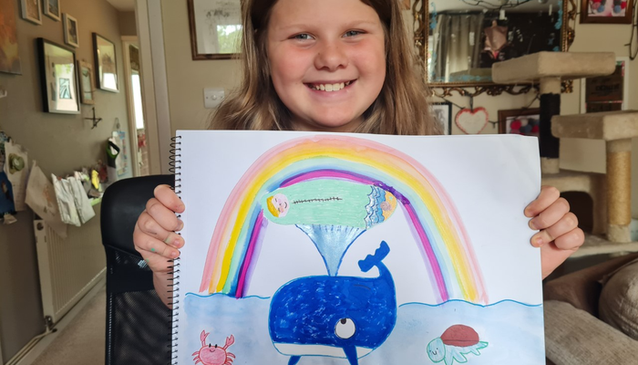 Eliza shows off her Action for Children Drawing Challenge entry